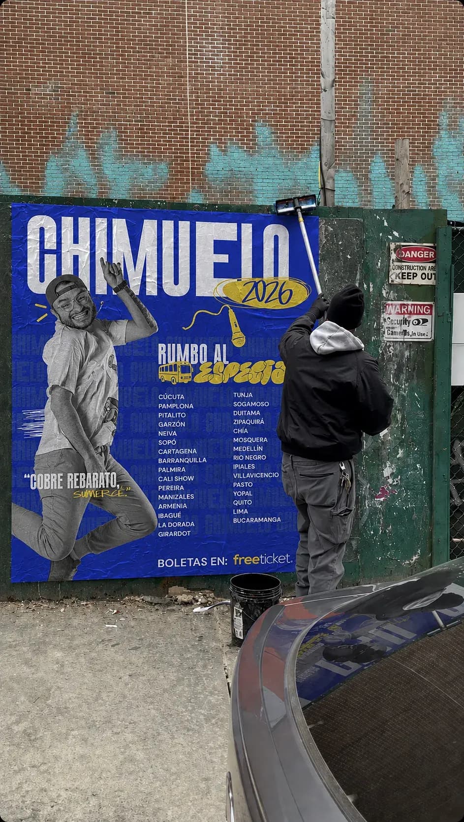 Una persona pega un afiche azul de Chimuelo en un poste junto a una moto.